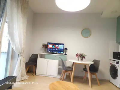 a living room with a table and chairs and a tv at Happy Inn Sweet Old Town Studio, Self check in, Parking in Vilnius