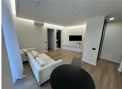 a living room with a white couch and a table at Rambynas R36 in Panevėžys