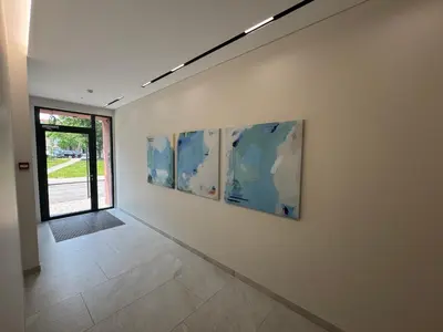 a hallway with four paintings on a wall at Rambynas R36 in Panevėžys