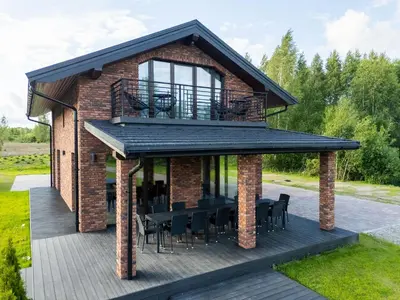 a house with a deck with a balcony at Galuonų vilos in Inturkė