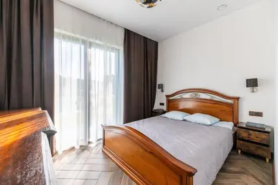 a bedroom with a bed and a large window at Galuonų vilos in Inturkė