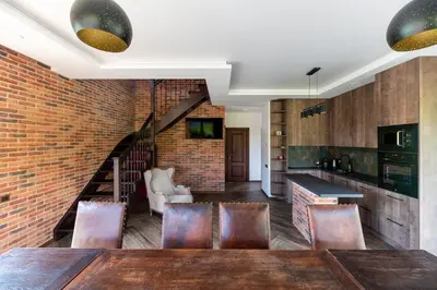a kitchen with a brick wall and a table and chairs at Galuonų vilos in Inturkė