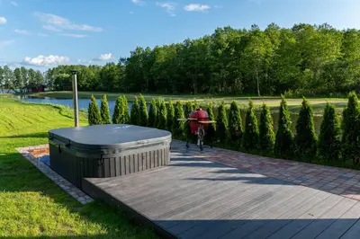 a person on a bike next to a wooden deck at Galuonų vilos in Inturkė