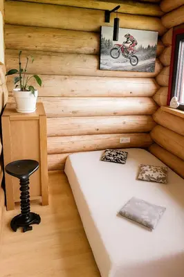 a room with a bed and a motorcycle on the wall at Kvapu sodyba