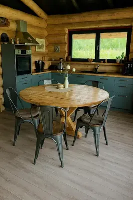 a kitchen with a wooden table and chairs in a room at Kvapu sodyba
