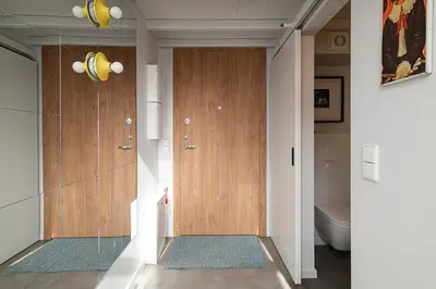 a hallway with two wooden doors and a toilet at Brand-new & Stylish Loft - Hip District Uptown by Reside Baltic in Vilnius