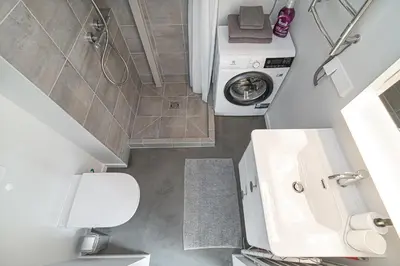 a bathroom with a sink and a washing machine at Brand-new & Stylish Loft - Hip District Uptown by Reside Baltic in Vilnius