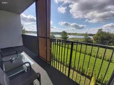 a balcony with a view of a field and water at Light House in Vilnius