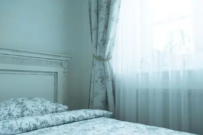 a bedroom with a bed with a curtain and a window at Provence Home in Vilnius