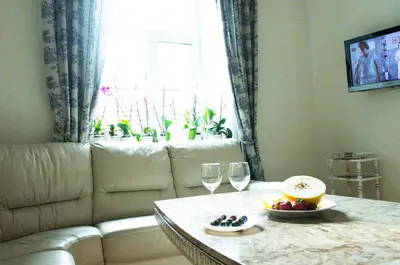 a living room with a couch and a table with wine glasses at Provence Home in Vilnius