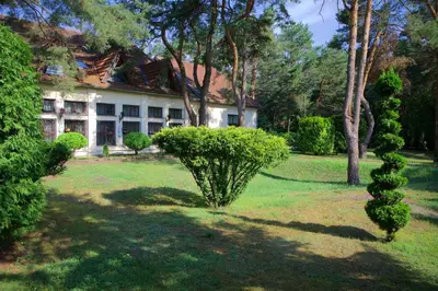a house with a heart shaped bush in the yard at Apartamentai Lampėdžiuose in Kaunas