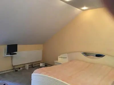 a small bedroom with a bed and a tv at Apartamentai Lampėdžiuose in Kaunas
