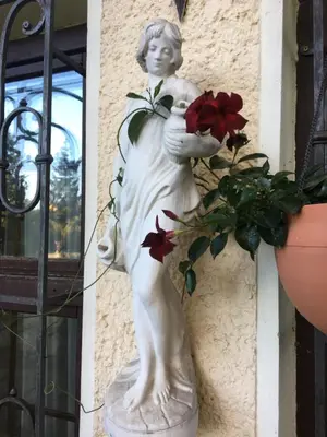 a statue of a woman holding flowers and a plant at Apartamentai Lampėdžiuose in Kaunas