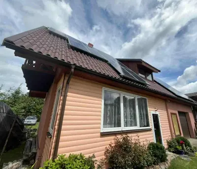 a house with a solar roof on top of it at Sodyba prie Ąžuolo