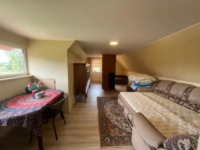 a bedroom with a bed and a table and a couch at Sodyba prie Ąžuolo