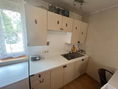 a kitchen with white cabinets and a sink and a window at Sodyba prie Ąžuolo