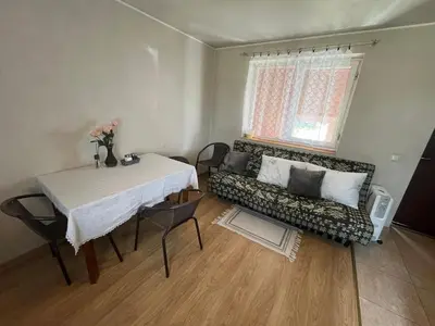 a living room with a table and a couch at Sodyba prie Ąžuolo