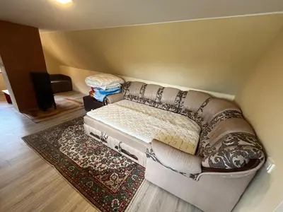 a couch sitting in a room with a rug at Sodyba prie Ąžuolo