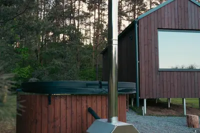 a small red building with a tub in front of it at MyRetreat - cabin for two