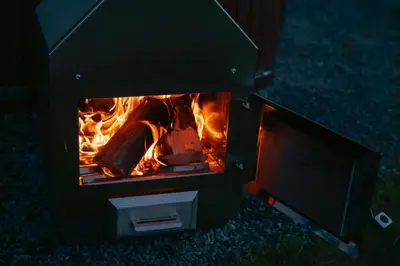 a stove with a fire inside of it at MyRetreat - cabin for two