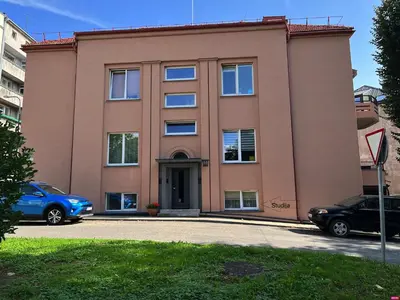 a pink building with cars parked in front of it at Cozy Traku Studio in Kaunas