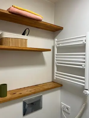 a bathroom with wooden shelves and a refrigerator at Cozy Traku Studio in Kaunas