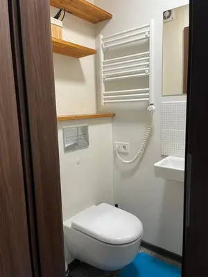 a bathroom with a white toilet and a sink at Cozy Traku Studio in Kaunas