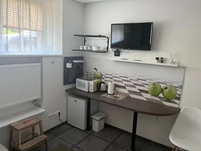 a kitchen with a table with a microwave and apples on it at Cozy Traku Studio in Kaunas