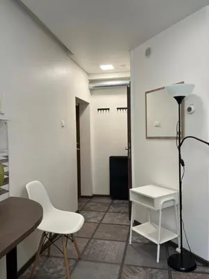 a room with white chairs and a table and a lamp at Cozy Traku Studio in Kaunas