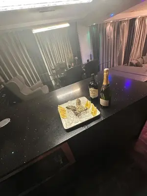 a table with a bottle of champagne and a plate of food at B&M Jacuzzi Rezidencija SELF CHECK - IN in Vilnius
