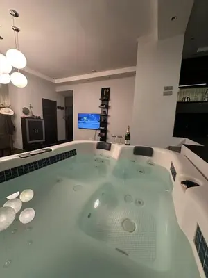 a large bath tub in a room with a television at B&M Jacuzzi Rezidencija SELF CHECK - IN in Vilnius