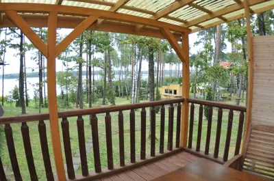 a screened in porch with a pergola and trees at Ppoilsio baze PAPARTIS in Luokesos Sen