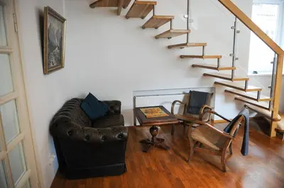 a living room with a couch and a table and stairs at Best Location 3 Bedroom Apartment in Vilnius