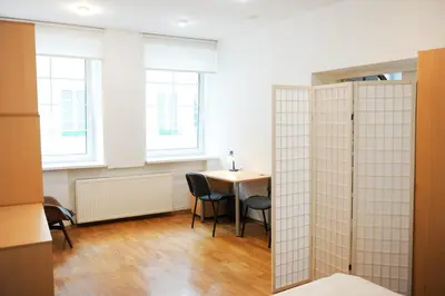 a room with a table and chairs and two windows at Best Location 3 Bedroom Apartment in Vilnius