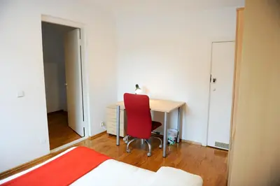 a bedroom with a desk and a red chair at Best Location 3 Bedroom Apartment in Vilnius