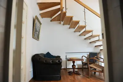 a living room with stairs and a table and chairs at Best Location 3 Bedroom Apartment in Vilnius