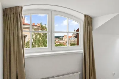 an arched window with a view of a city at Elegant Apartments in Vilnius Center, 11 in Vilnius