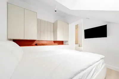 a white bedroom with white cabinets and a bed at Elegant Apartments in Vilnius Center, 11 in Vilnius