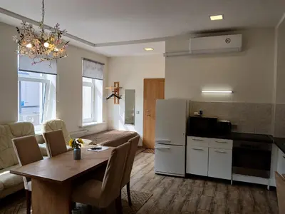 a kitchen and living room with a table and a refrigerator at Big apartment in city center in Kaunas