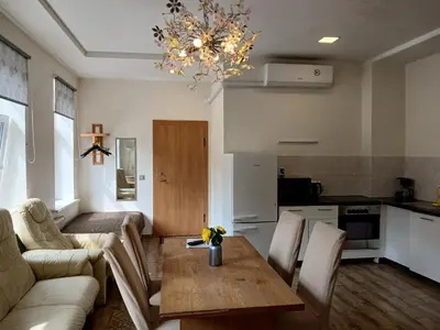 a living room with a couch and a table and a kitchen at Big apartment in city center in Kaunas