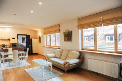 a living room with a couch and a table at Rooftop Charm Stylish 2BDR Steps from Town Hall in Vilnius
