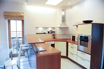 a kitchen with a counter top and a refrigerator at Rooftop Charm Stylish 2BDR Steps from Town Hall in Vilnius