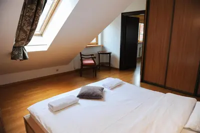 a bedroom with a white bed with two pillows on it at Rooftop Charm Stylish 2BDR Steps from Town Hall in Vilnius
