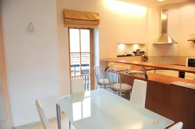 a kitchen with a table and chairs and a counter top at Rooftop Charm Stylish 2BDR Steps from Town Hall in Vilnius