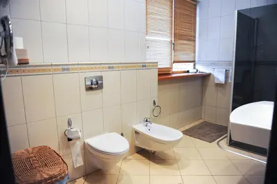 a bathroom with a toilet and a sink at Rooftop Charm Stylish 2BDR Steps from Town Hall in Vilnius
