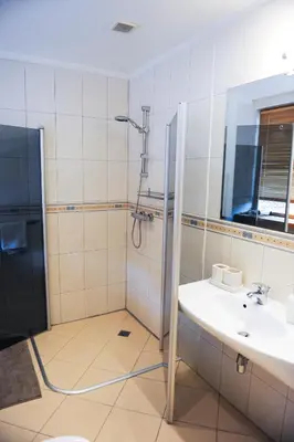 a bathroom with a shower and a sink at Rooftop Charm Stylish 2BDR Steps from Town Hall in Vilnius