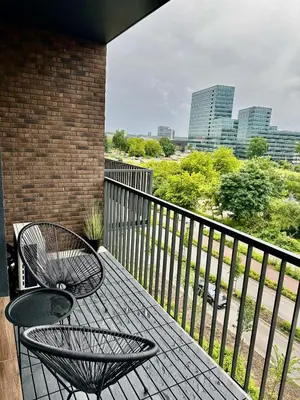 a table and chairs on a balcony with a view of a city at Flat in Vlinius city center in Vilnius