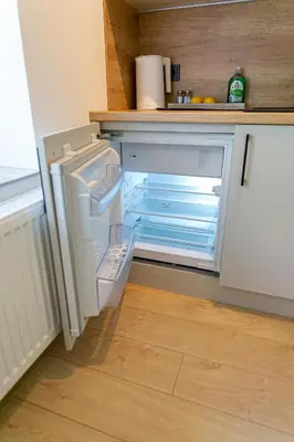 an empty refrigerator with its door open in a kitchen at Green Apartment with free parking in Kaunas