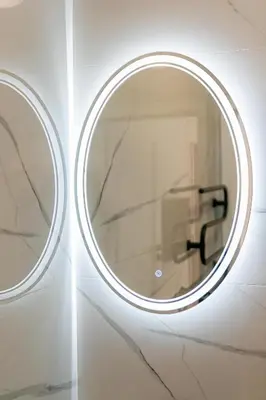 a round mirror on a wall in a bathroom at Green Apartment with free parking in Kaunas