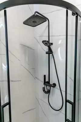 a shower with a shower head in a bathroom at Green Apartment with free parking in Kaunas